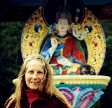 Lama Inge in front of Guru Rinpoche statue fountain
